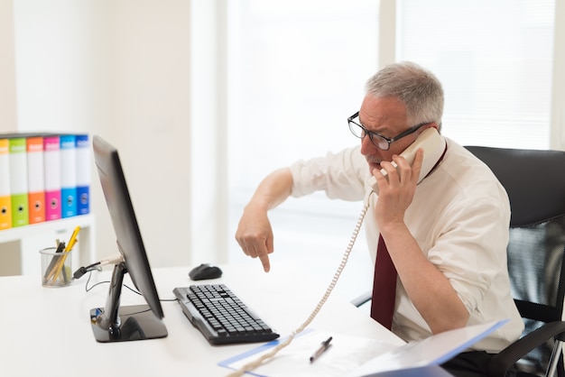 Annoyed businessman having a discussion while talking on the phone Premium Photo