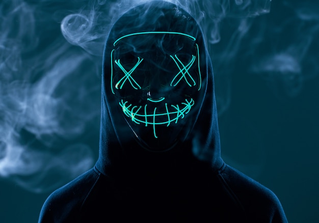 Premium Photo | Anonymous man hiding his face behind neon mask in a ...