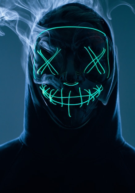 Premium Photo | Anonymous man hiding his face behind neon mask in a ...