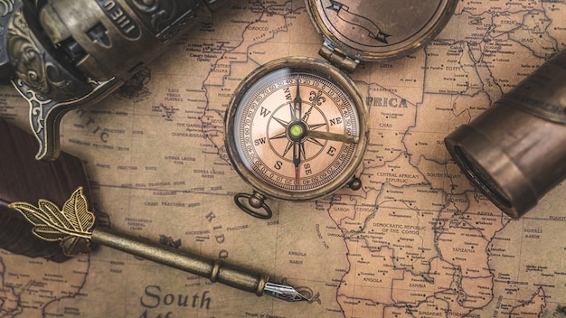プレミアム写真 アンティークコンパスと旧世界地図の羽ペン
