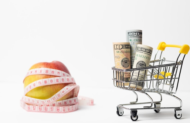 Premium Photo Apple Wrapped In A Centimeter Shopping Cart With Money