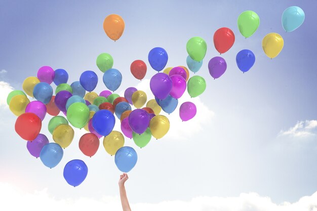 Arm releasing balloons Free Photo