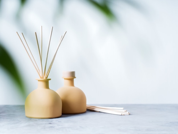 Download Aroma reed diffuser home fragrance with rattan sticks on a light background with palm leaves ...