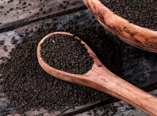 Premium Photo | Aromatic black tea loose or dried tea leaves on wooden ...