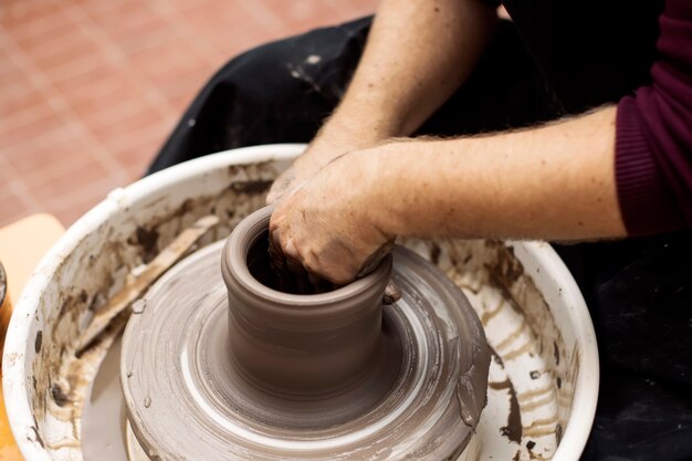 Premium Photo | Artist makes clay pottery on a spin wheel