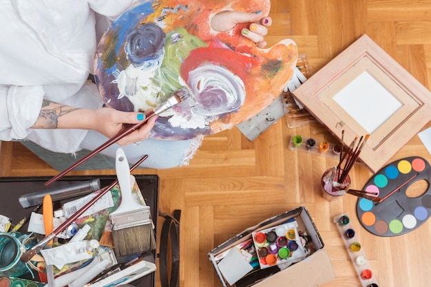Artist mixing dye on palette Free Photo