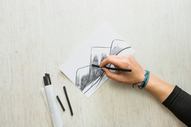 Free Photo | Artist's hand sketching drawing on white paper with ...