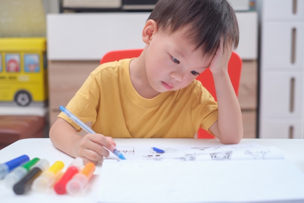 アジア3 4歳の幼児男の子子供の書き込み 鉛筆での描画 宿題をしている学生 幼稚園の幼稚園テストの準備 プレミアム写真