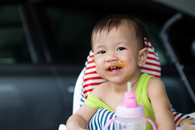 Asian Baby Eating Food On High Chair Age Of 8 Months Premium Photo