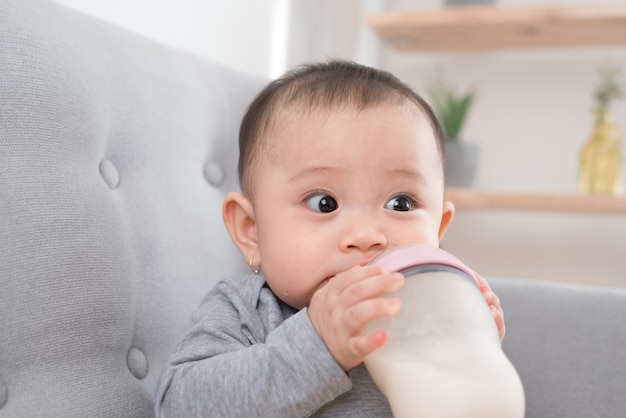 哺乳瓶からミルクを食べるアジアの赤ちゃん 生後 9 か月 プレミアム写真