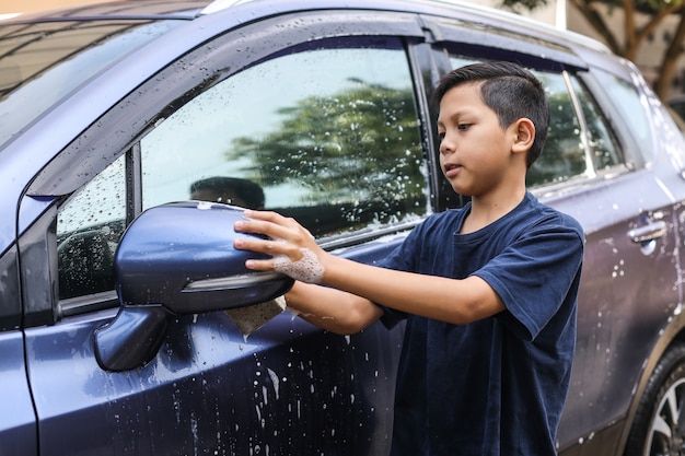 Premium Photo | Asian boy clean the car rearview mirror ...