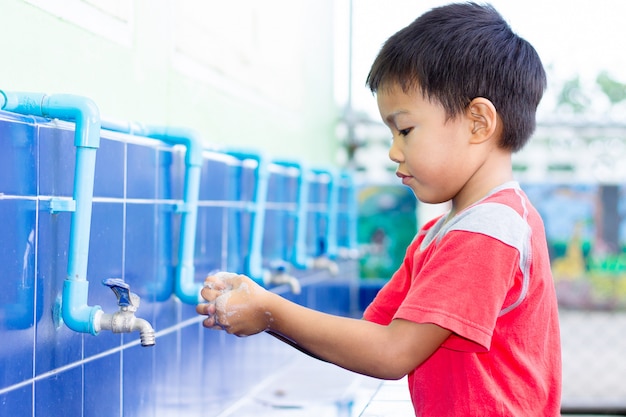 Premium Photo | Asian child boy washing his hands before eating food.