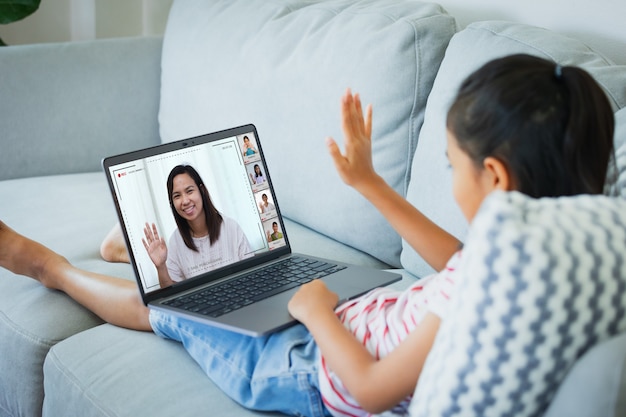 Premium Photo | Asian child girl sitting on sofa and having video ...