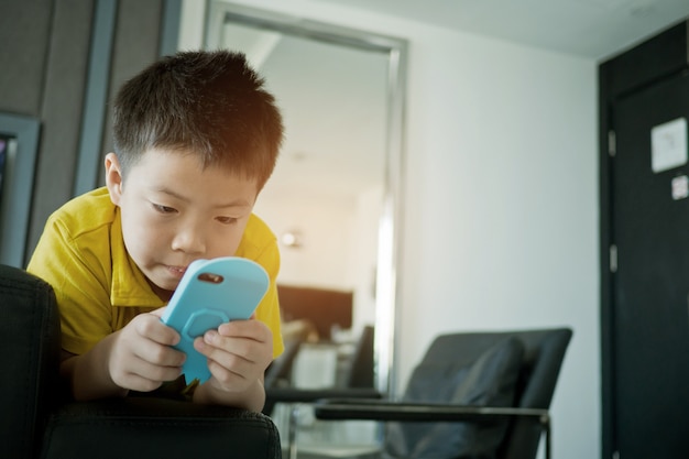 Premium Photo | Asian chinese boy playing smartphone on bed, kid use ...