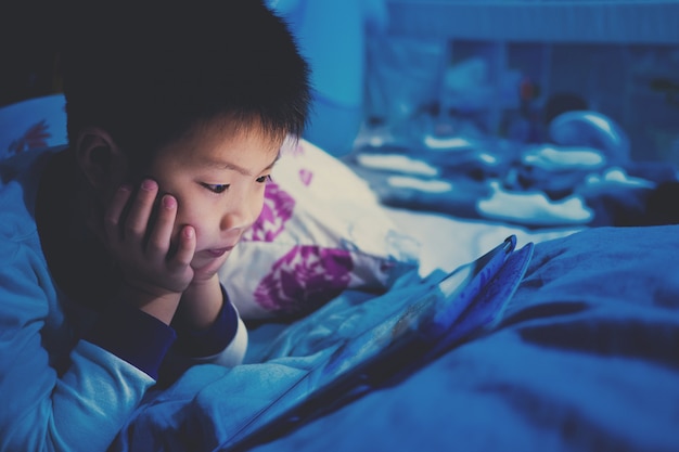Premium Photo | Asian chinese boy playing smartphone on bed, kid use phone  and play game