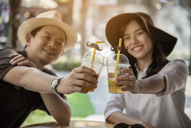 Asian couple enjoy traveling sitting at coffee shop Free Photo