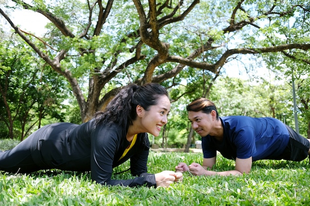 Premium Photo | Asian couple exercising and planking workout together on  grass field in the garden