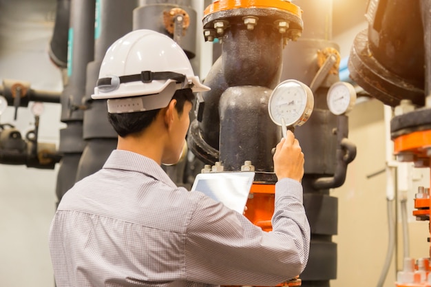 Asian engineer maintenance checking  condenser water  pressure gauge Premium Photo