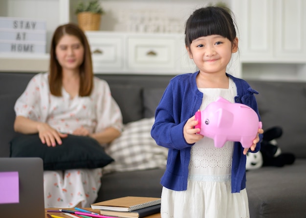 Premium Photo | An asian family is teaching daughter on savings money with  a piggy bank, financial planning concept