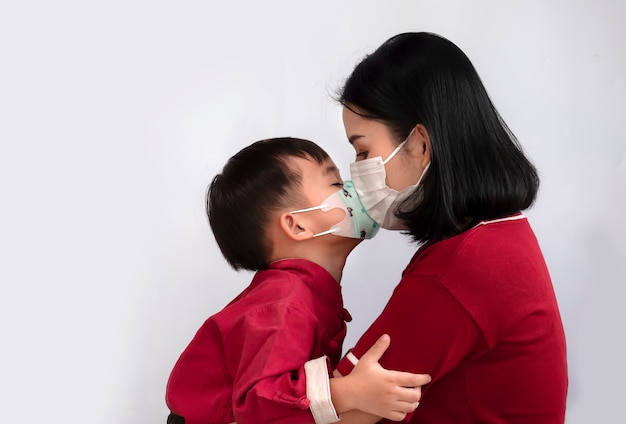 Asian Family Of Mom And Son Are Kissing And Wearing Mask To Protect
