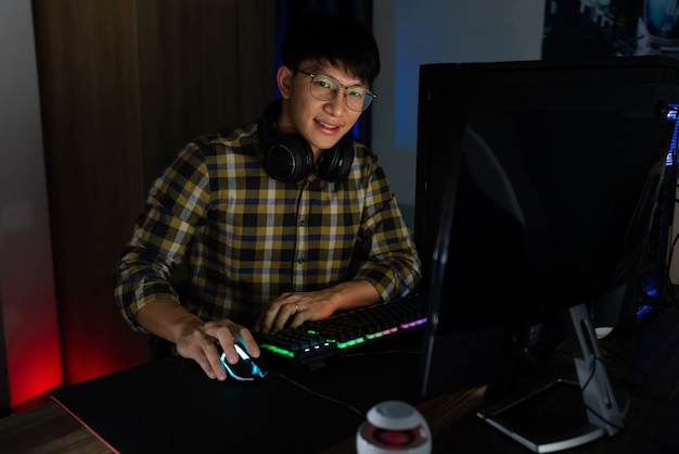 Premium Photo | Asian gamer guy in headphones enjoy and rejoicing while ...