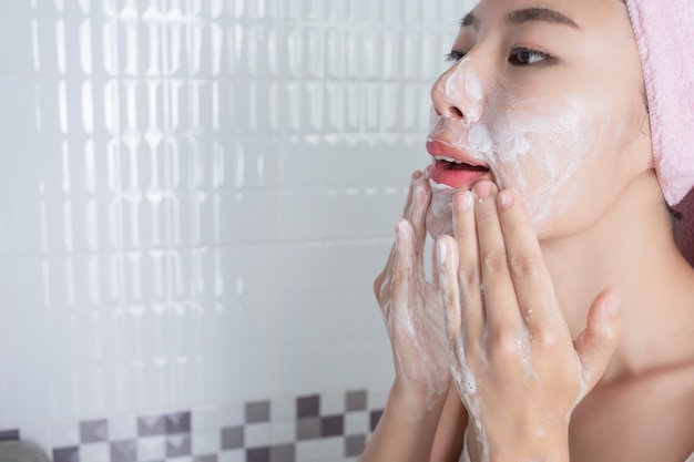 Asian girl washes face. Free Photo