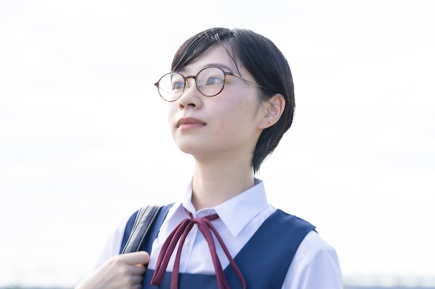 空を見上げる眼鏡をかけたアジアの女子高生 プレミアム写真