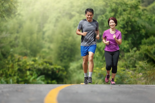 Premium Photo | Asian middle aged couple jogging exercise in park