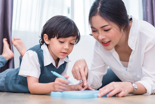 Premium Photo | Asian mom teaching cute boy to drawing in board with color  pen