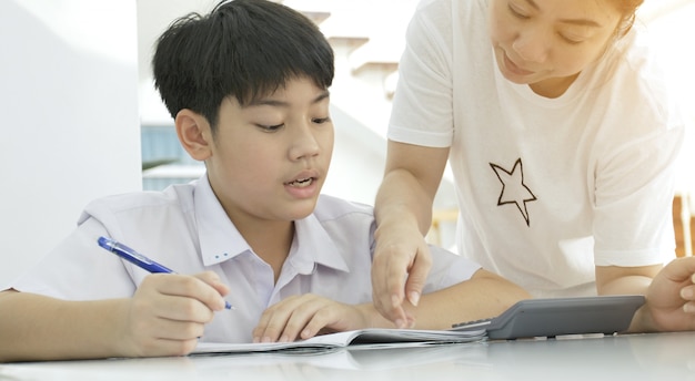 Premium Photo Asian Mother Helping Her Son Doing Homework On White Table
