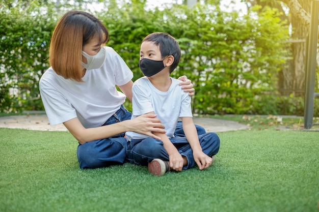 Asian mother and her son wearing protective masks Premium Photo