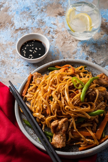 Premium Photo | Asian noodles with pork in teriyaki sauce, with green ...