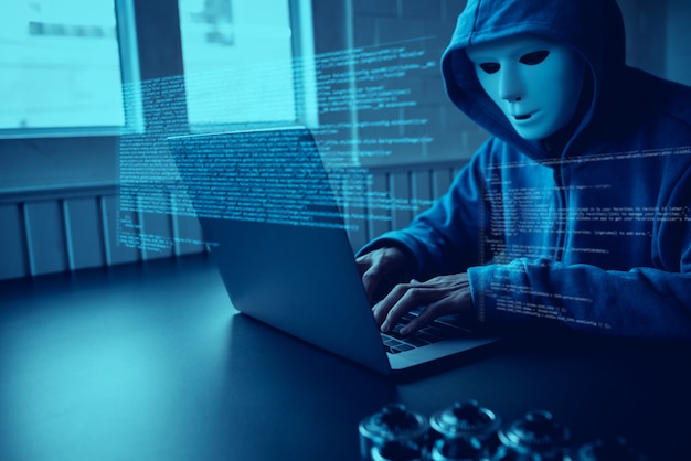 Азиатские люди хакер носить маску, используя ноутбук кибер-атак. | Премиум  Фото