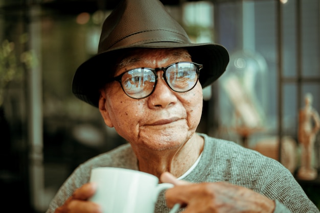 Asian Senoir Old Man Retirement Drinking Coffee In Cafe