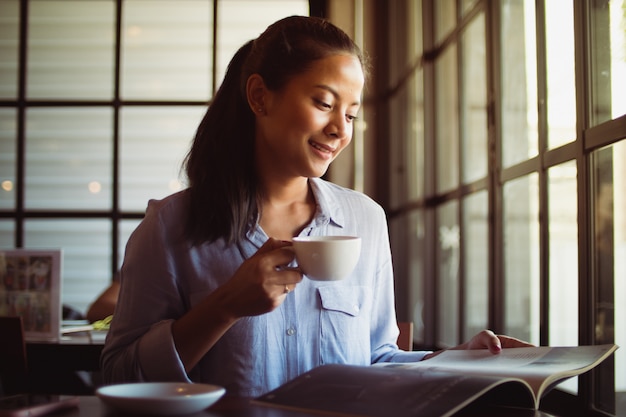 Asian woman drinking coffee in cafe Premium Photo