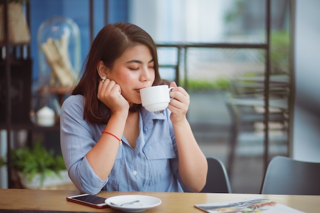 Premium Photo | Asian woman drinking coffee in coffee shop cafe and using  mobile phone