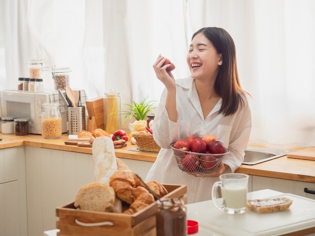 Premium Photo | Asian woman eating fruit in the kitchen