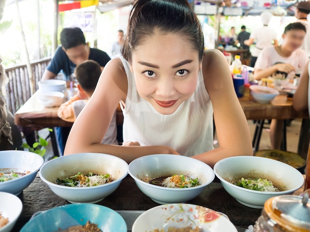 Premium Photo | Asian woman eating noodle in thai local restaurant in thailand.