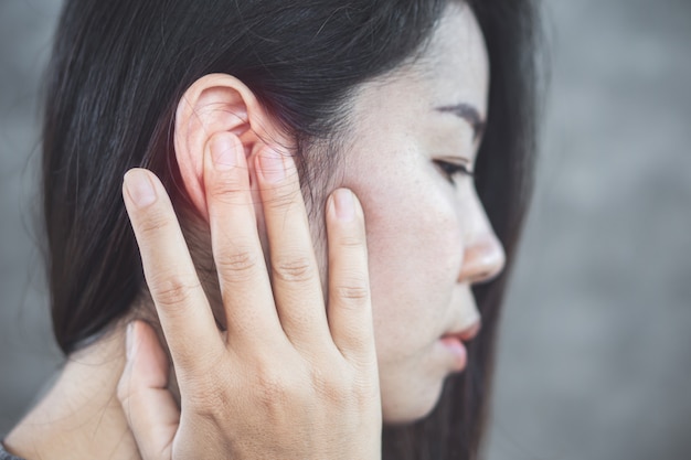 Asian woman has pain in the ear, tinnitus concept Premium Photo