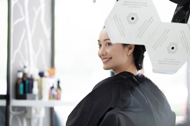 Asian woman i'm dyeing my hair in a beauty salon | Premium Photo