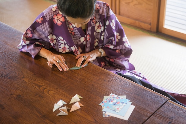 asian woman making origami with japanese paper free photo