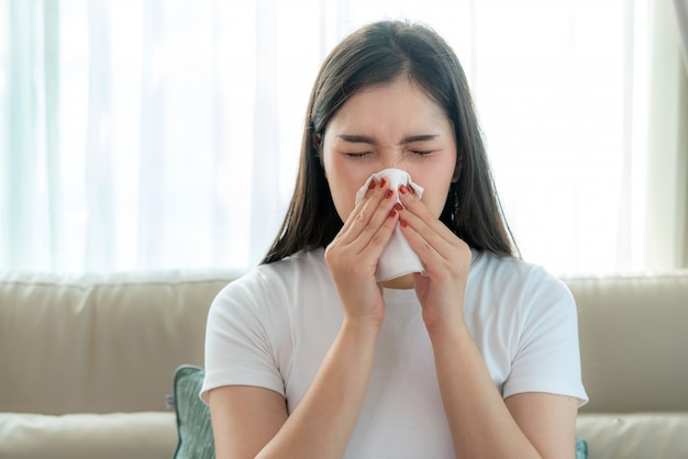 Premium Photo | Asian woman sick and sad with sneezing on nose and cold  cough on tissue paper because influenza and weak or virus bacteria from  dust weather or smoke for medical.