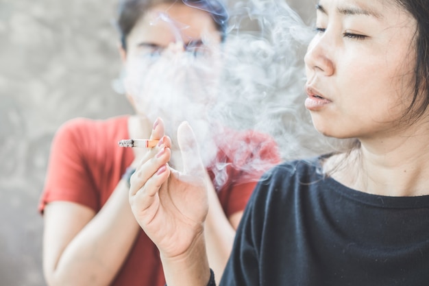 Premium Photo | Asian woman smoking cigarette near people in family