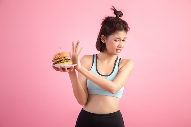 Asian women refuse fast food because of slimming on pink Free Photo
