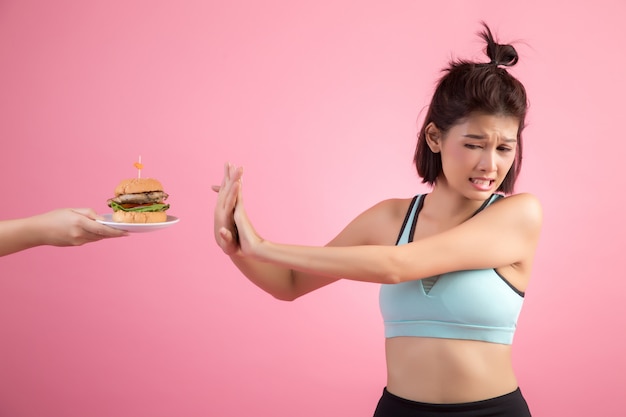 Asian women refuse fast food because of slimming on pink Free Photo