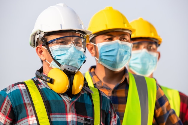 Premium Photo | Asian workers wear protective face masks for safety in ...