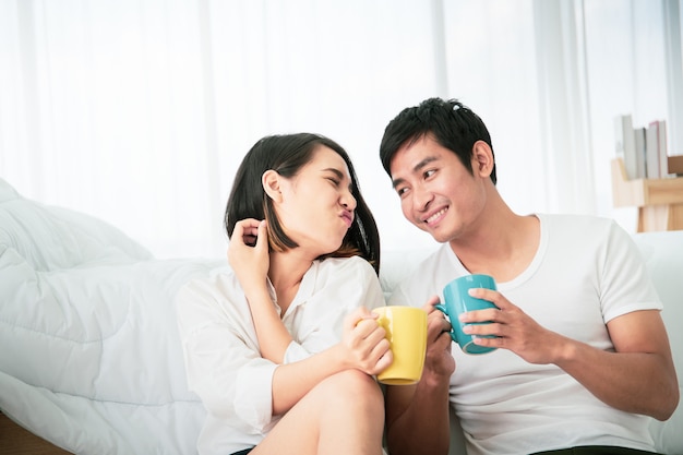 Premium Photo | Asian young couple enjoying together with coffee in the  morning in badroom, concept of leisure, couple, relationship and valentine.  photograph with copy space