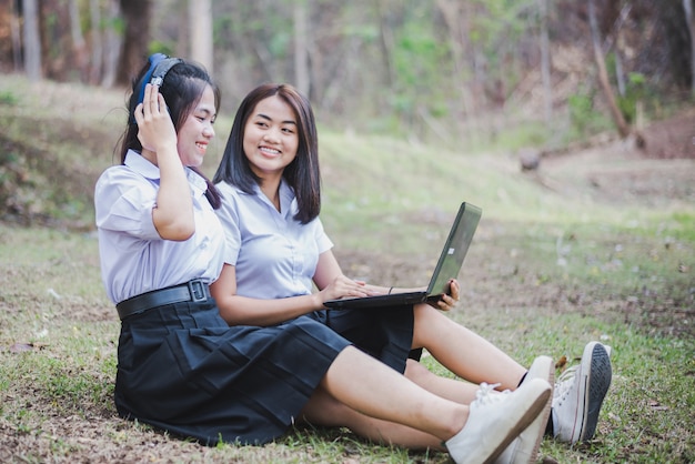 学校の制服を着たアジアの若い女の子は タイの田舎で教育とコミュニケーションのためにラップトップを使用しています プレミアム写真