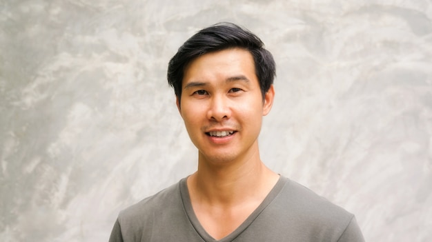 Asian Young Man Smiling On A Gray Background Photo