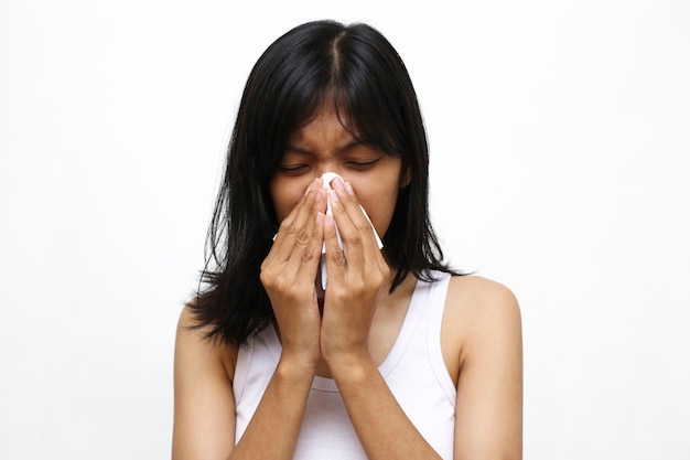 アジアの若い女性のくしゃみや咳を白で隔離 プレミアム写真